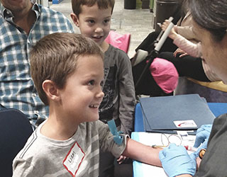 Boy smiling at nurse while having blood drawn