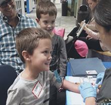 Niños sonriendo mientras les sacan sangre